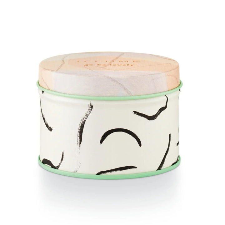 Illume Coconut Milk Mango Fleur Tin Candle. Pink pastels and mint green tin. Top reads "Illume Go be lovely".