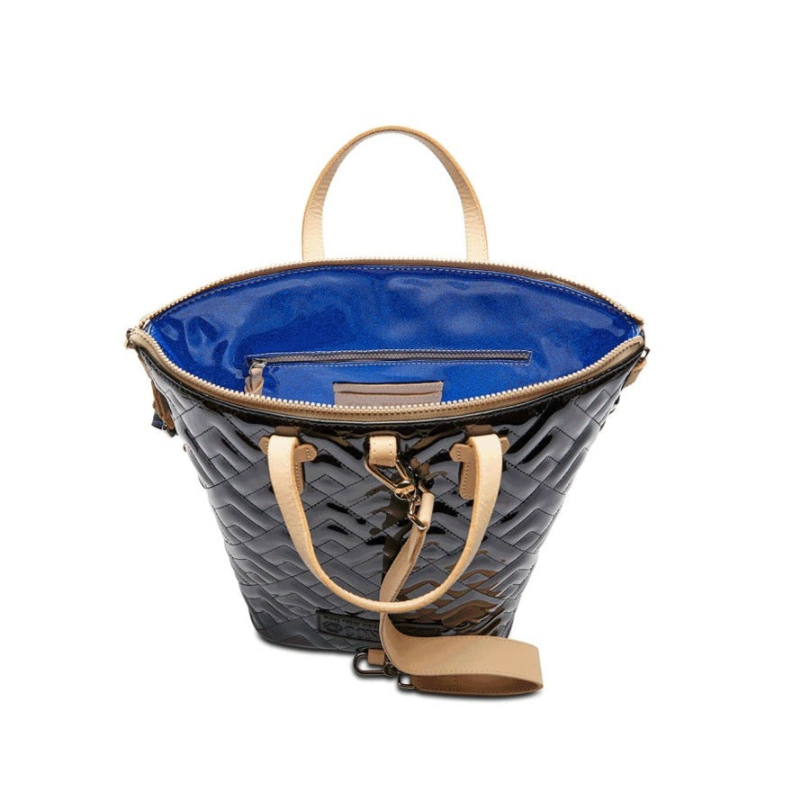 Inked Sling | Consuela | The glossy black bag with Diego leather accents and unzippered to show the sparkly blue interior.