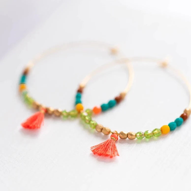 Large Tiny Orange Tassel Hoops | Nest Pretty Things | Gold hoops with orange, brown, blue, green, and gold beads, plus a tiny orange tassel.