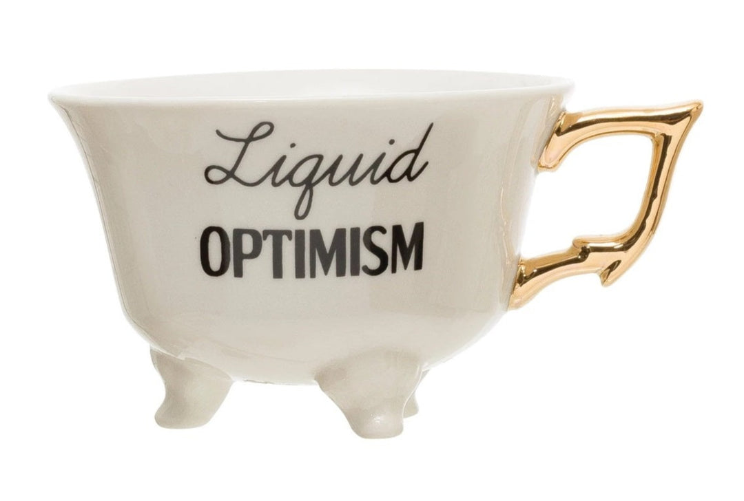Saying Teacups | White Teacup with little feet and a gold handle. Reads "Liquid Optimism".