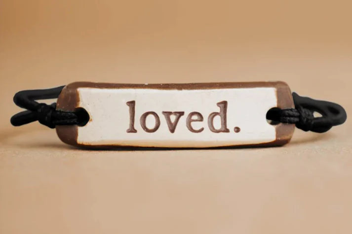 MudLOVE Original Bracelet | "Loved." ceramic piece with a black elastic cord.