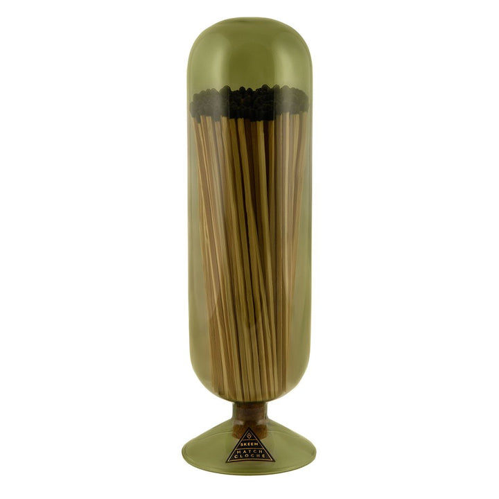 Skeem Olive Fireplace Match Cloche | An olive colored match cloche with long fireplace matches inside. Photo taken against a white background.