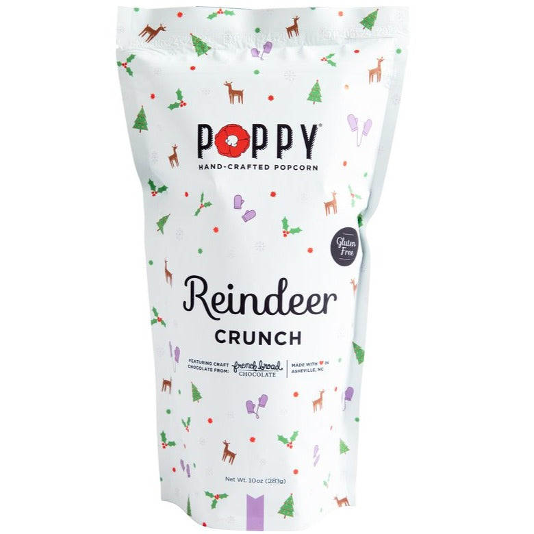 Holiday Poppy Popcorn | A white bag with little reindeer, Christmas trees, holly, and purple mittens. Text reads "Poppy Hand-crafted popcorn, reindeer crunch, featuring craft french broad chocolate, made with love in Ashville, NC. Gluten free, Net Wt. 10oz (283g).