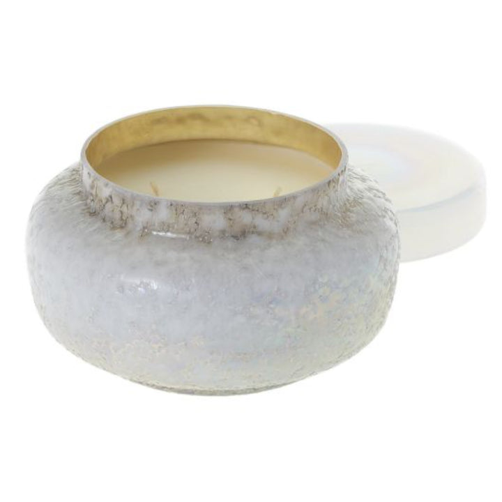 Daydream Scented Purity Candle. White shimmery candle with textured background and a gold inner rim. Photo taken against white background.