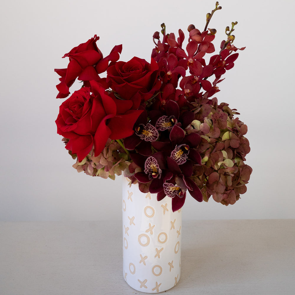All red arrangement in a xo vase with red roses, orchids and hydrangea. Valentines flower delivery 