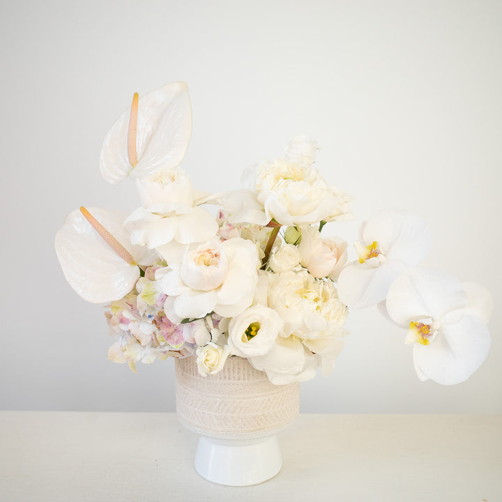 White floral arrangement in a ceramic vase. Sympathy Flowers | Anthonys funeral home | Florist with Luxe blooms 