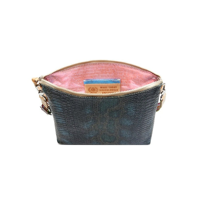 Rattler Downtown Crossbody | Consuela | A top down photo showcasing the pink textured interior with a pocket and the Consuela motto "Make Today Ridiculously Awesome!".
