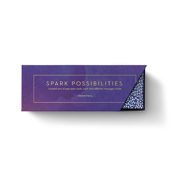 Spark Possibilities | Pop-Open Cards | 3 boxed sets of pop-open cards, each with different messages inside. A purple/blue box with the part of the inner boxes showing on the side. Photo taken against a white background.