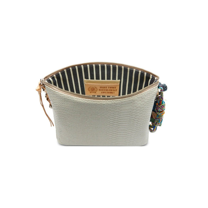 Thunderbird Downtown Crossbody | Consuela | A cream/gray crossbody bag with nude accents and a black/white striped interior with the Consuela motto "Make Today Ridiculously Awesome". Hanging on the right side is a cluster of colorful keepsakes.