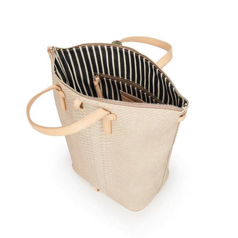 Thunderbird Sling | Consuela | A rattlesnake pattern bag with nude accents. Photo shows the interior of the bag. It has a black and white striped pattern.