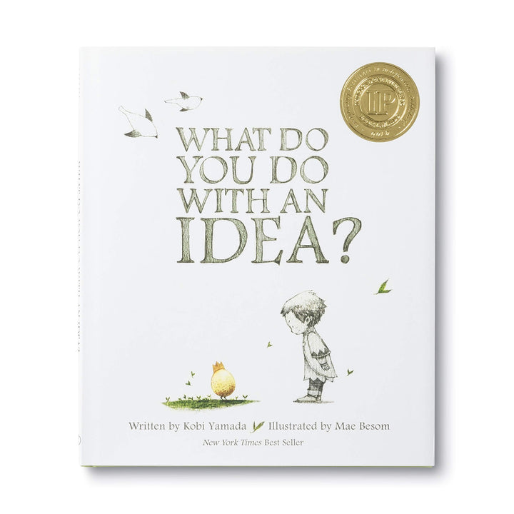 What Do You Do With An Idea? | A modern whit cover with an illustration of a child looking down at and egg with a crown.
