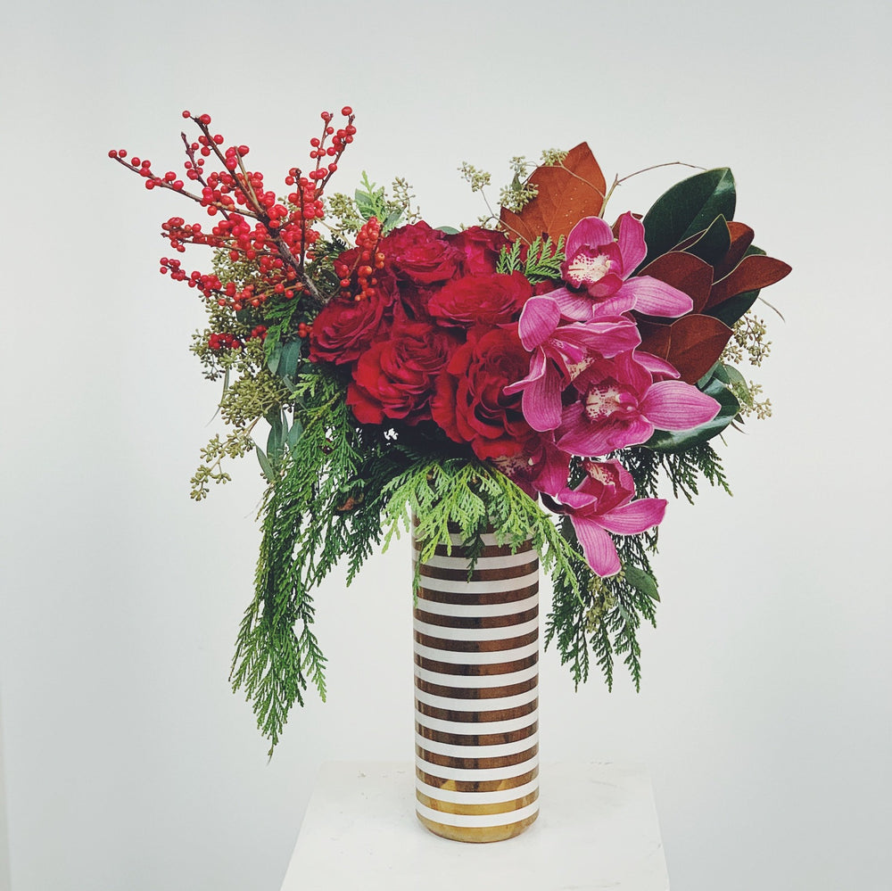 Dozen roses with orchids in stripe vase with white background