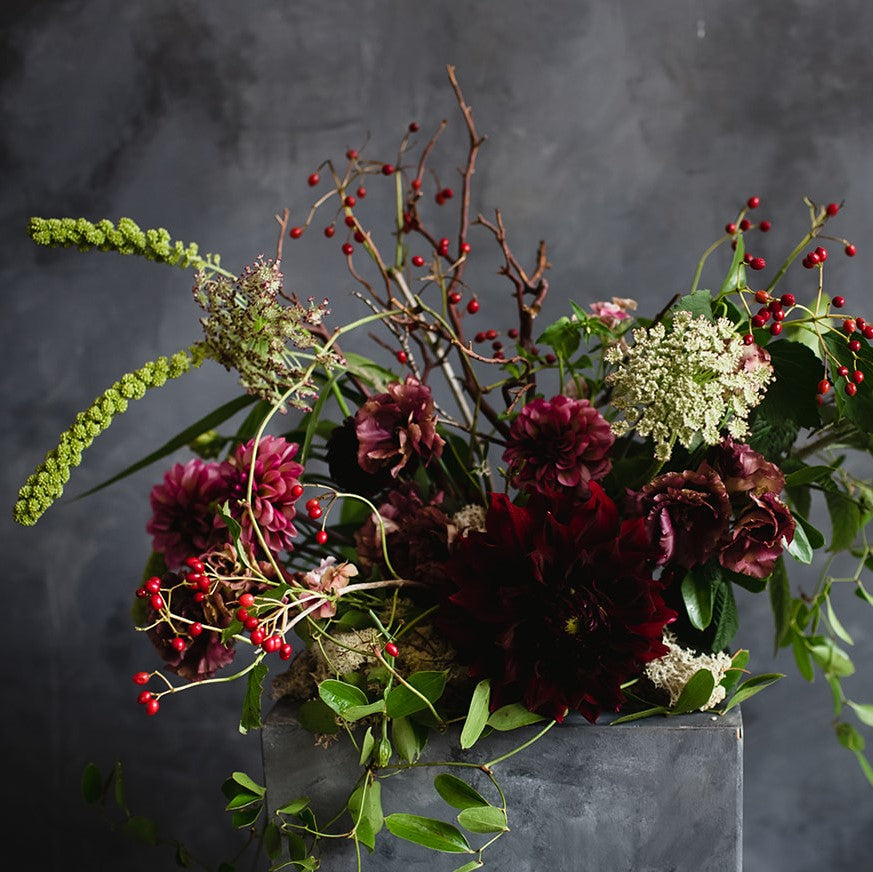 Stacy K Floral | A red and green woodland style arrangement with dahlihas, red berries, branching, and more.