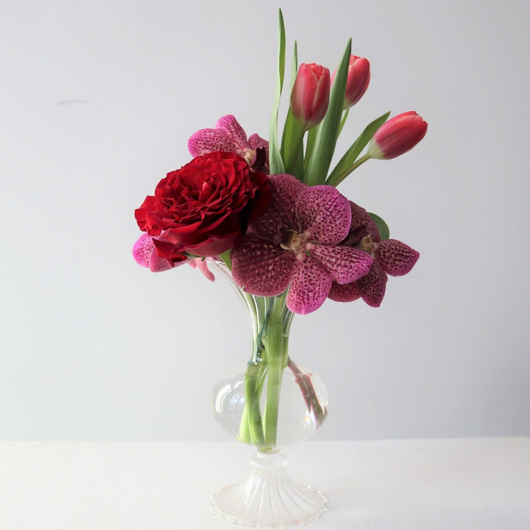 Clear bud vase with a red rose, purple orchid and pink tulips  Rochester NY Florist