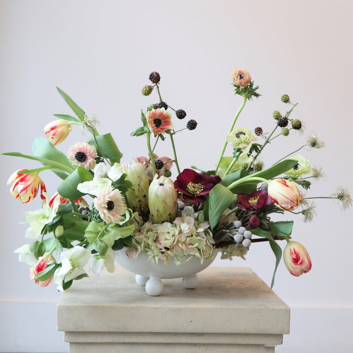 An arrangement with anemone, protea, helleborus, tulips, berries, brunia and hydrangea.