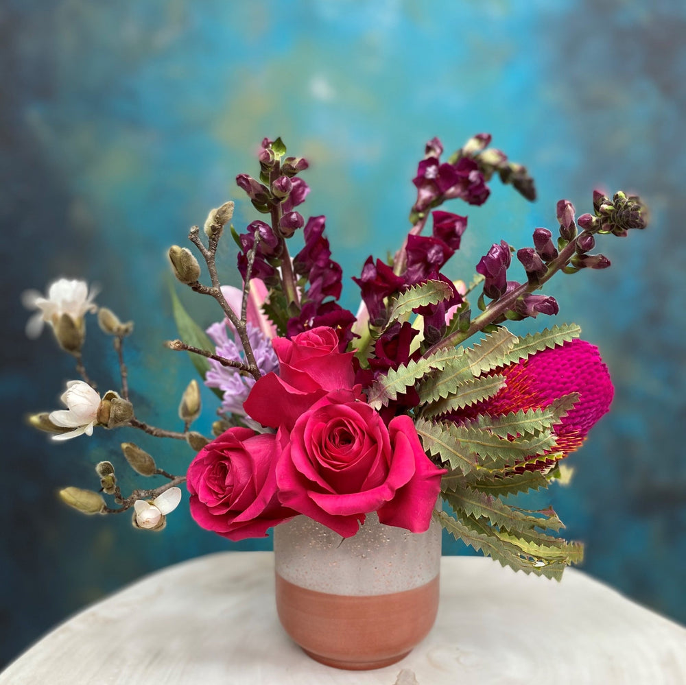 rose gold vase with protea arrangement