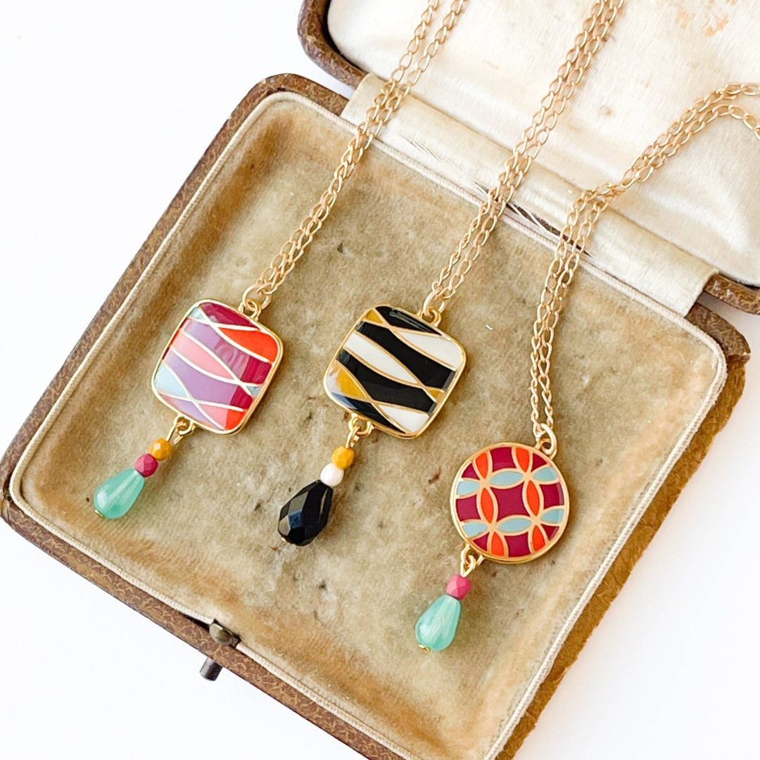 Nest Pretty Things | Mid-Century Pendant Necklace Assorted | Comes in red/orange/blue striped, red/orange/blue patterned, or black/white/yellow striped. With gold accents.