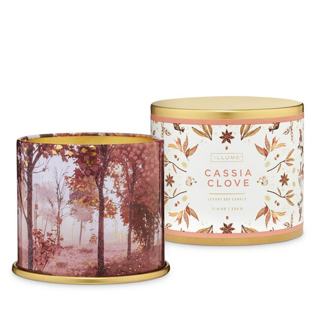 Cassia Clove scented candle with lid removed revealing pink/red forest on the sides. Photo taken againstt white background.