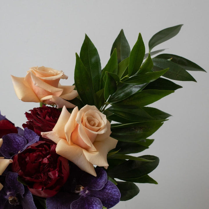 Peach Roses, Red Peonies and orchids with greenery close up.  Rochester NY Flower Delivery