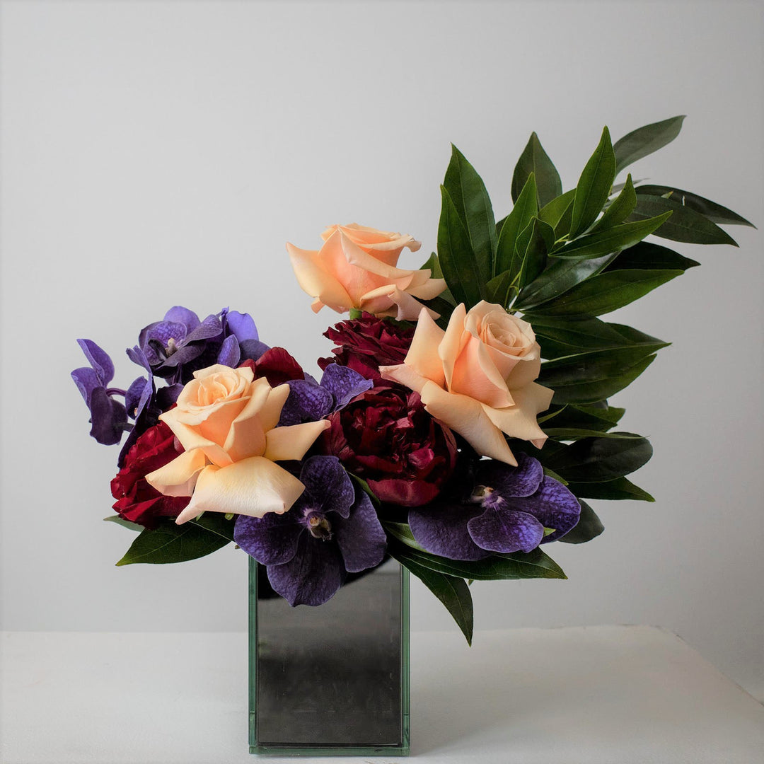 Mirrored vase with orchids, peonies and roses. Flower Delivery