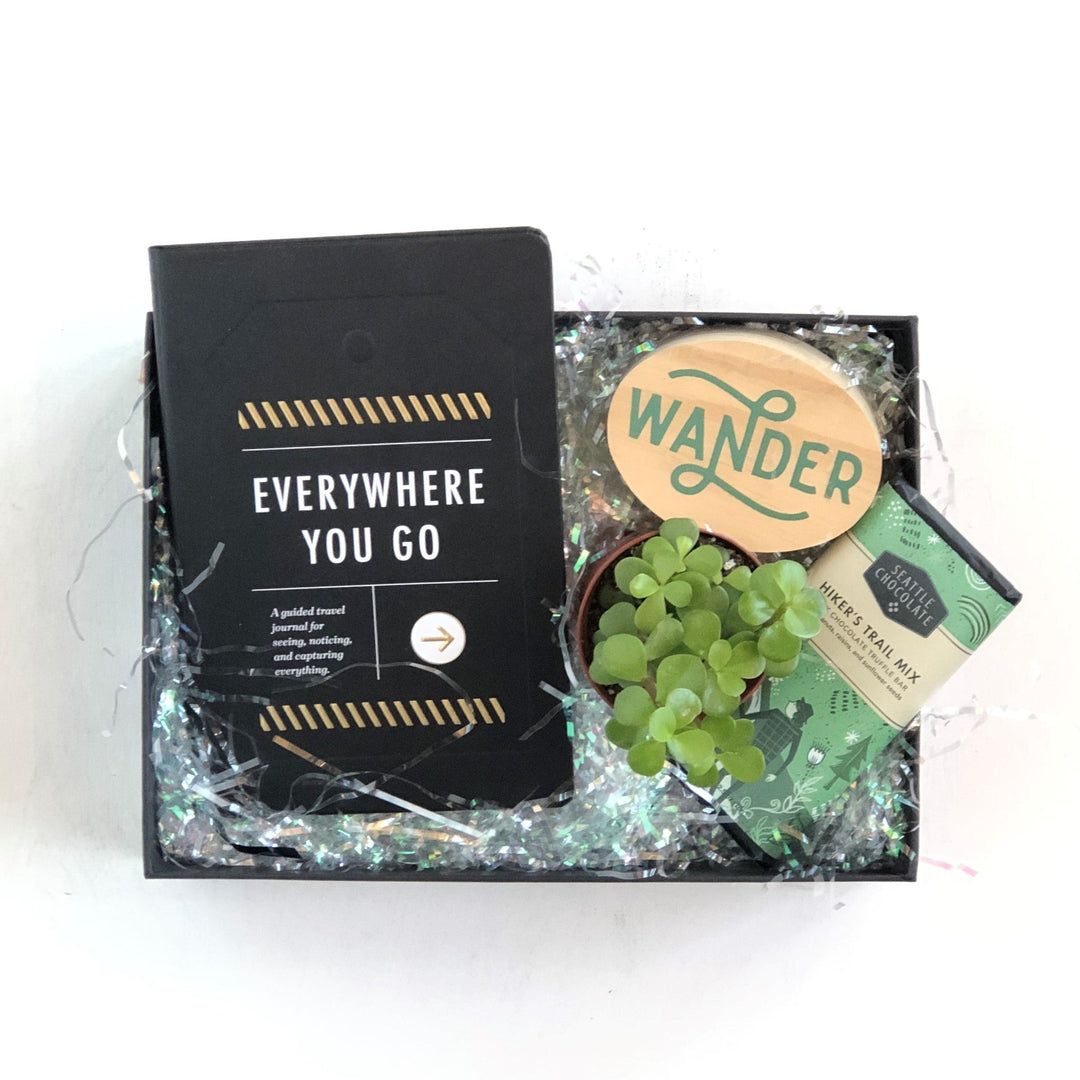 Gift Box featuring "Everywhere You Go" booklet, small plant, Seattle Chocolate hiker's trail mix, and small wood block "Wander" sign.