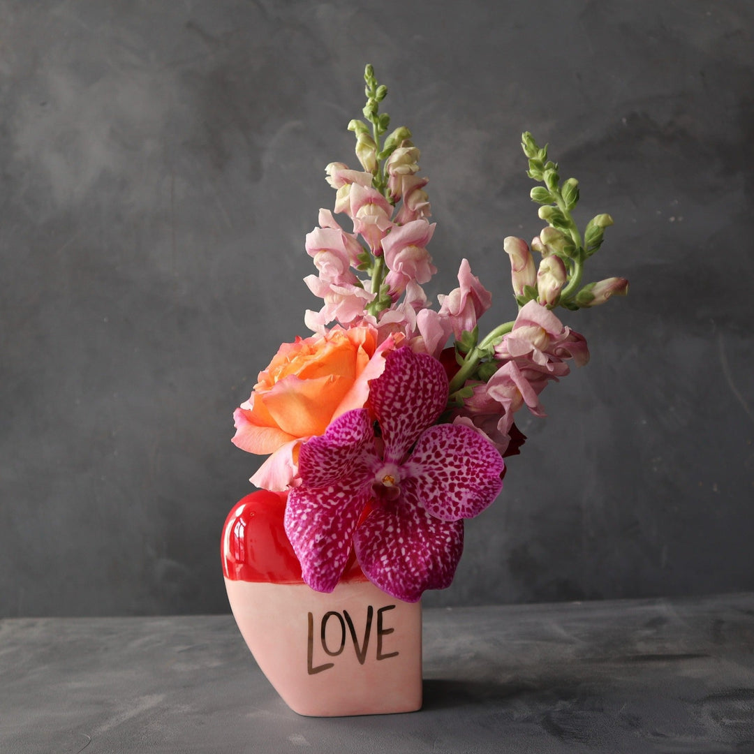 Orchid, rose and snapdragons in a pink and red Love bud vase