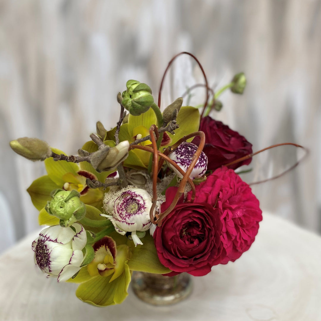 garden rose, orchids and ranunculus arrangement in pinks and greens