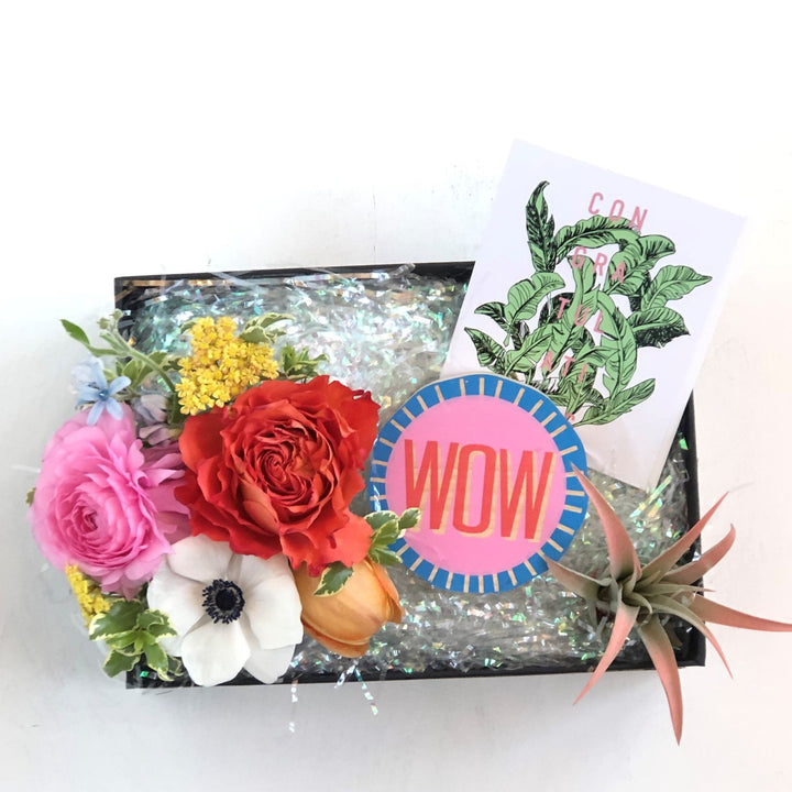 Gift Box featuring a small floral arrangement, congratulations card, airplant, and small wood block "wow" sign.